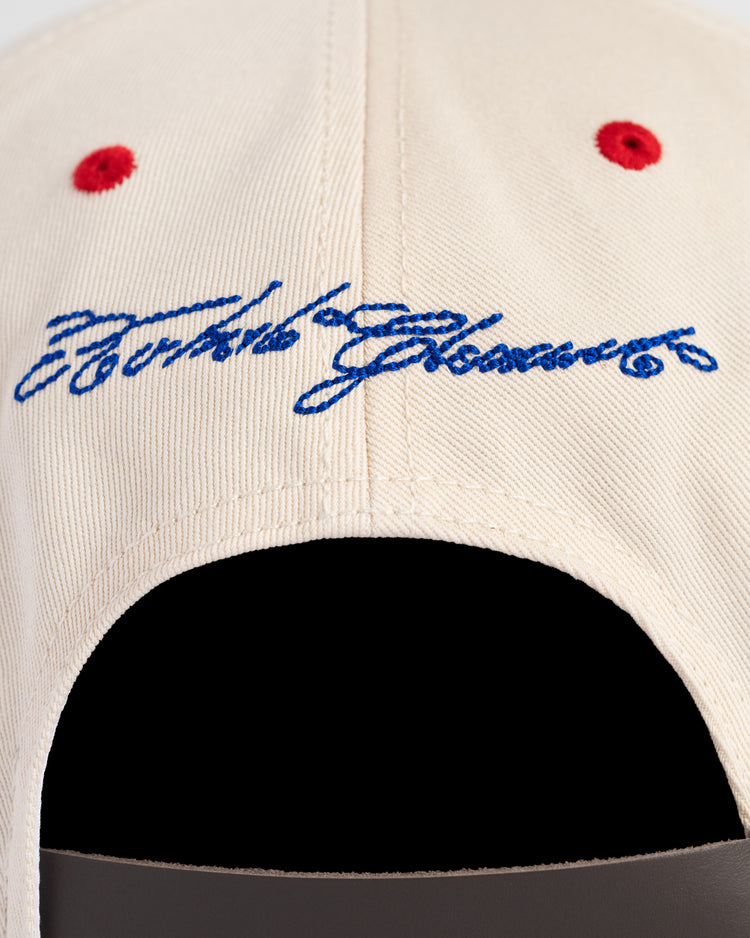 Close-up of the back of the Ebbets Field Santurce Cangrejeros Cotton Twill Ballcap, a beige cap with red eyelets and blue cursive embroidery above the opening—a stylish tribute to Puerto Rican baseball.