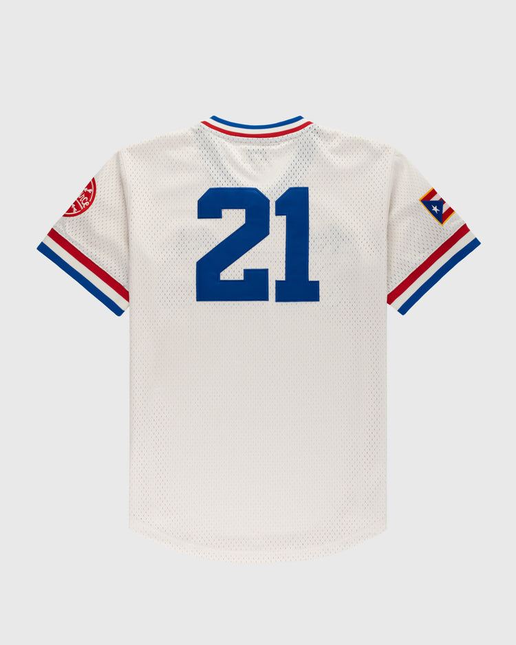 The Ebbets Field Santurce Cangrejeros Mesh V-Neck Jersey features white mesh, blue 21 on the back, red and blue sleeve stripes, and sleeve patches including a Puerto Rican flag—an iconic piece of Puerto Rican baseball.