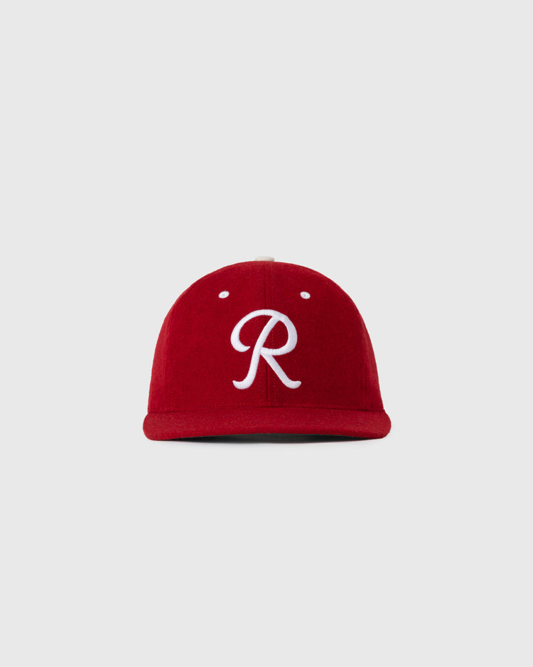 The EFF Seattle Rainiers 1955 Authentic Wool Ballcap features a red design with a white cursive R on the front, shown on a plain light gray background.