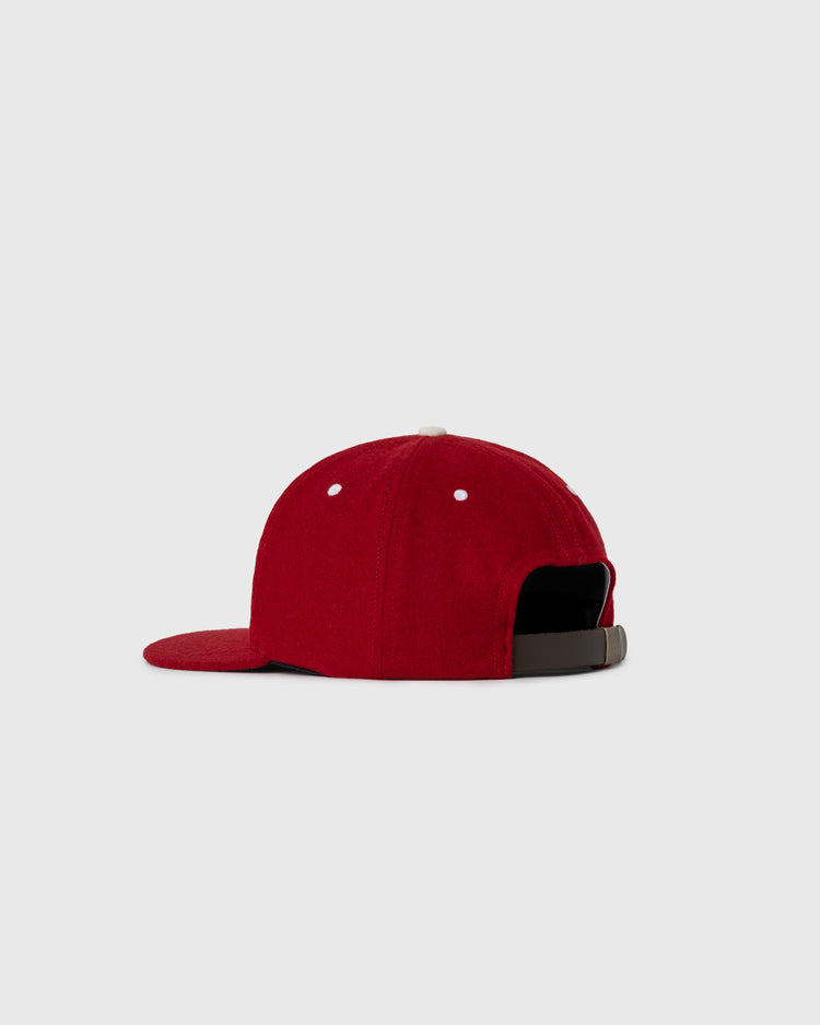 The EFF Seattle Rainiers 1955 Authentic Wool Ballcap, shown from the back, features a red design with white metal eyelets and an adjustable brown strap, set against a plain light gray background.