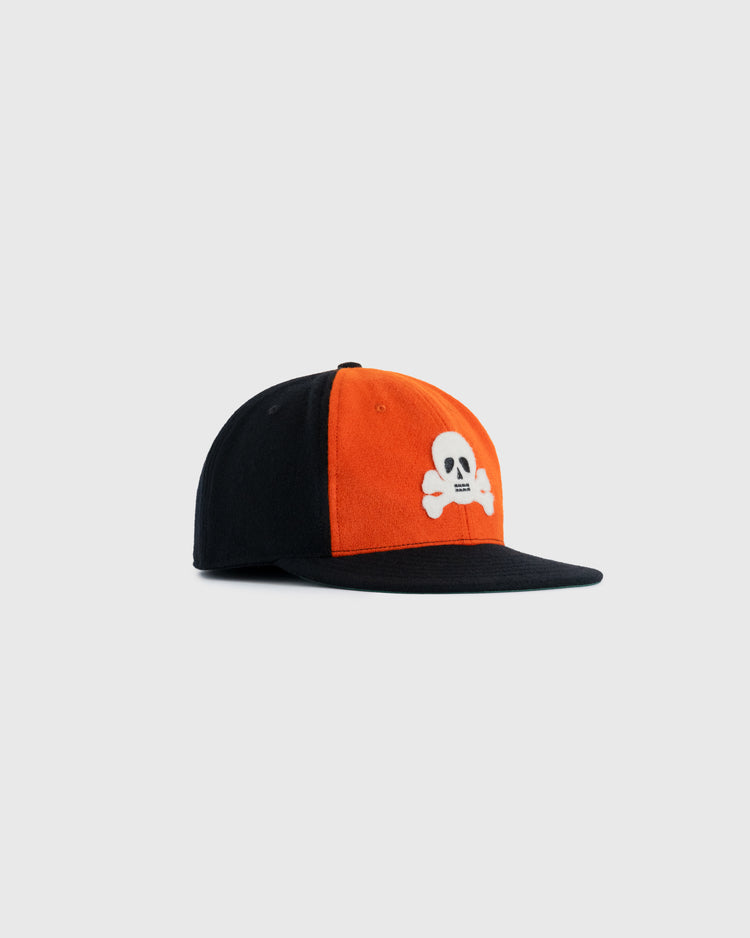 The EFF Sioux City Ghosts 1935 Authentic Wool Softbrim Ballcap features a two-tone design with an orange front, black sides and brim, and a white skull and crossbones on the front.
