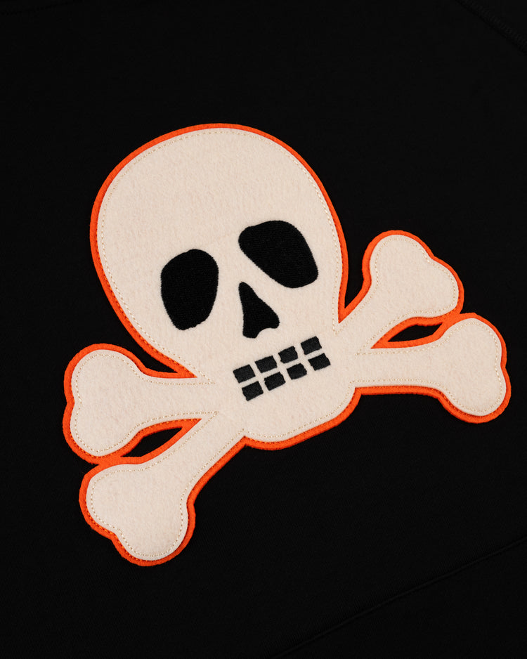 The EFF Sioux City Ghosts French Terry Felt Pullover Hoodie features a white skull and crossbones with black details on a black background, outlined in orange—a nod to historic barnstorming teams in fast-pitch softball.