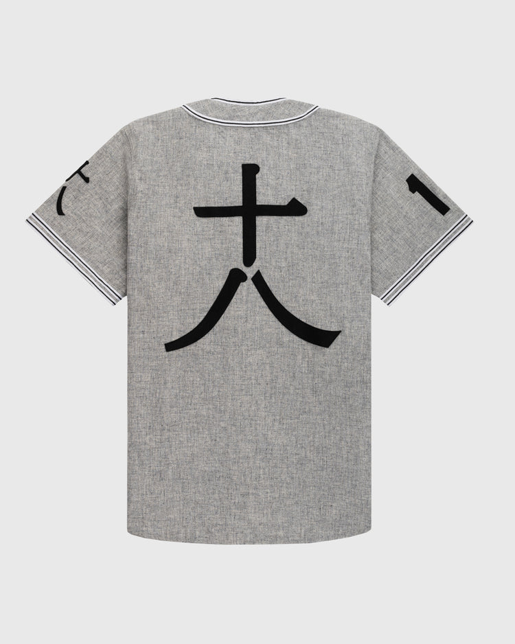 The Tokyo Kyojin (Giants) 1936 Authentic Wool Road Baseball Jersey by Ebbets Field Flannels features a gray short-sleeve design, bold black 大 kanji on the back, partial black sleeve accents, and striped collar and cuffs—echoing classic Japanese jerseys.