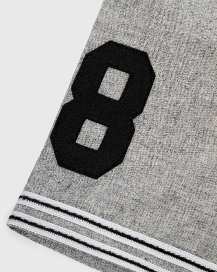 Close-up of the Tokyo Kyojin (Giants) 1936 Authentic Wool Road Baseball Jersey by Ebbets Field Flannels, featuring a gray flannel fabric, large black number 8, and two white-striped black bands along the edge.