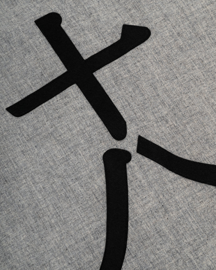 A close-up of black abstract shapes on light gray textured fabric, echoing details from the Ebbets Field Flannels Tokyo Kyojin (Giants) 1936 Authentic Wool Road Baseball Jersey.