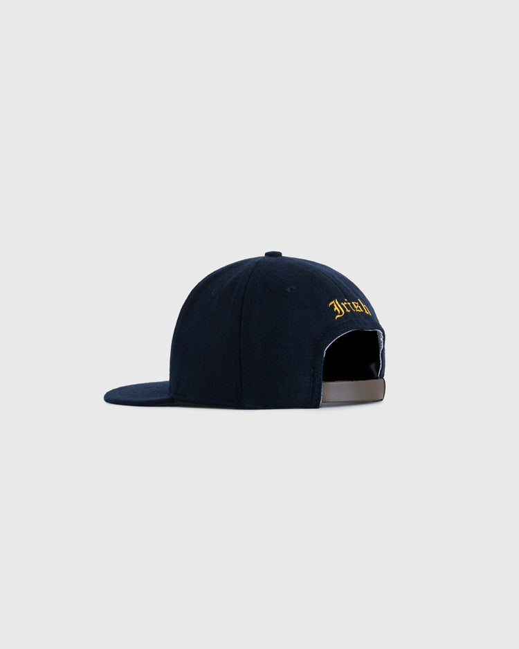 The EFF University of Notre Dame Leprechaun Authentic Wool Ballcap, shown from the back on a light gray background, features collegiate-inspired yellow embroidery and an adjustable strap with a metal buckle.