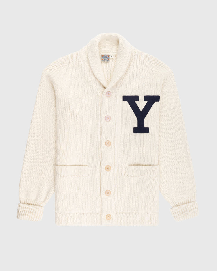 The EFF Yale University 1923 Wool Shawl Collar Sweater features a cream vintage style, long sleeves, two front pockets, five buttons, and a large black “Y” appliqué on the chest, inspired by classic Yale Football varsity knits.