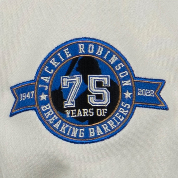 The EFF Jackie Robinson French Terry Script Hooded Sweatshirt - Natural features a circular patch with 75 Years of Breaking Barriers, the years 1947 and 2022, a blue number 75, and a baseball player silhouette—a perfect tribute to the anniversary.
