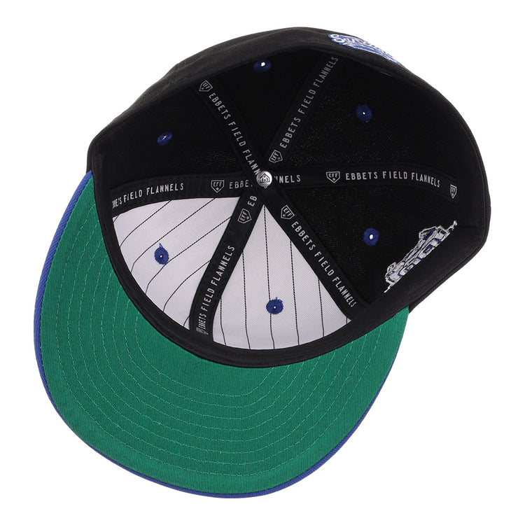 The Santurce Cangrejeros NLB Flip Fitted Ballcap - Black by EFF features a green undervisor, white pinstriped lining, blue rivets, and a black Ebbets Field Flannels label—honoring the Puerto Rican League with its classic Santurce logo.