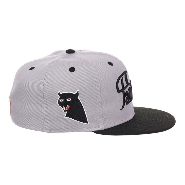 The EFF Montreal Black Panthers NLB Flip Fitted Ballcap in gray features a black brim, an embroidered black panther head with red fangs on the side, and stylized black lettering on the front for a vintage look.