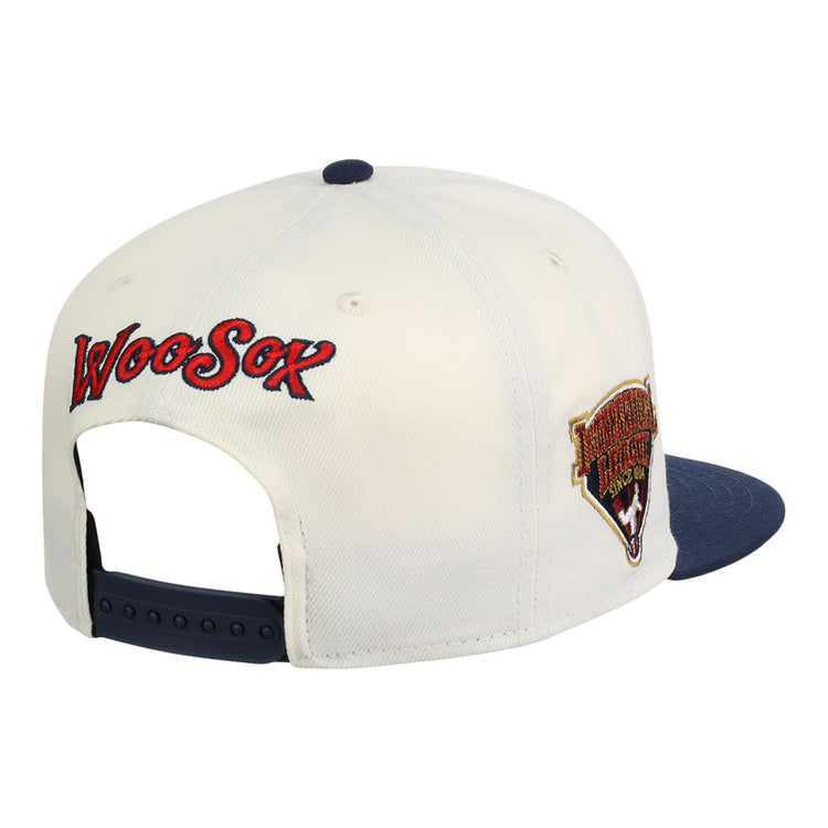 The Ebbets Field Worcester Red Sox MiLB Snapback Ballcap features a cream crown, navy brim, adjustable strap, WooSox embroidered in red and blue on the back, and a team logo patch on the side.
