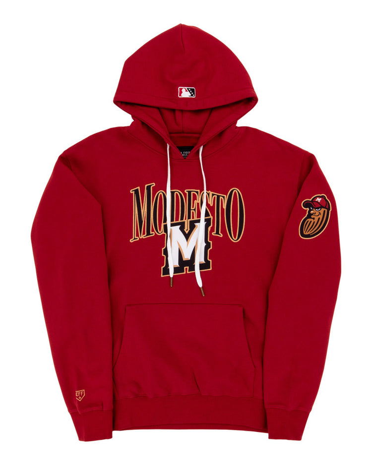 The Ebbets Field Modesto Nuts MiLB Cotton Hooded Sweatshirt is a red hoodie with MODESTO and a large gold and white M on the front, a red bird head patch on the left sleeve, and an MLB logo on the hood.