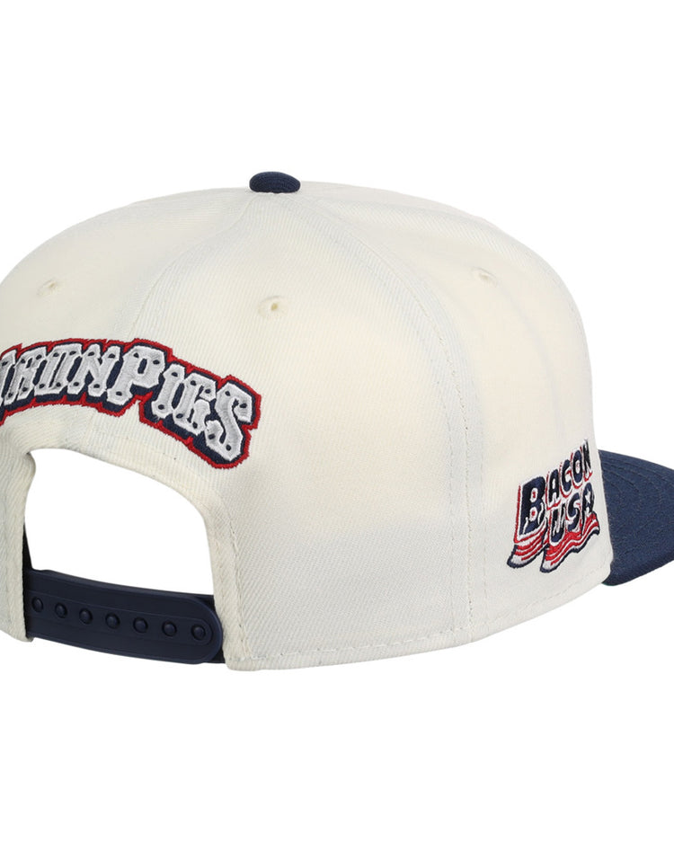 The Ebbets Field Lehigh Valley Ironpigs MiLB Snapback Ballcap is a white cap with a navy brim and adjustable strap, plus embroidered 
