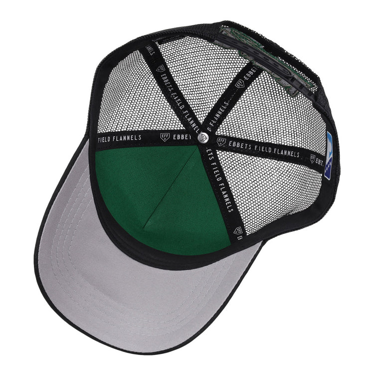 A top-down view of the inside of the black Dayton Dragons MiLB Trucker Ballcap by Ebbets Field, featuring a gray brim, green interior panel, and inner bands with 