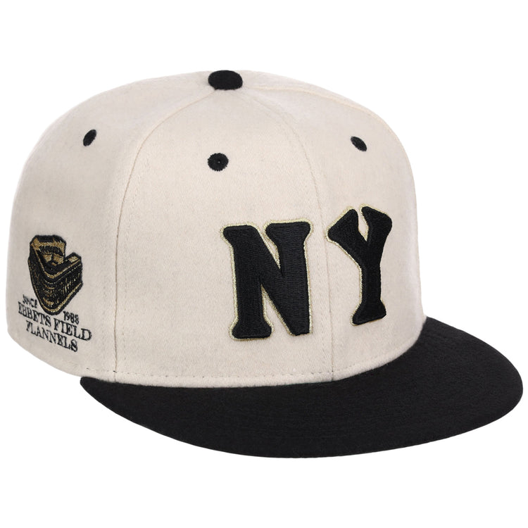 The Ebbets Field New York Black Yankees NLB Ballpark Fitted Ballcap is cream with a black brim, large black NY letters on the front, and an embroidered patch with text and logo on the side.