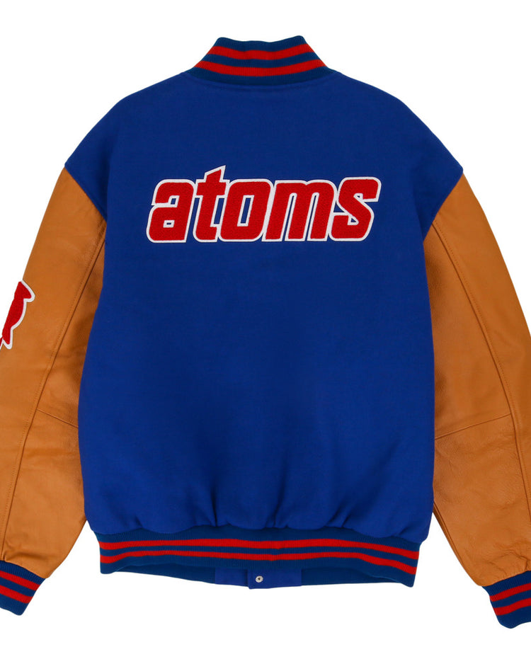 The Sankei Atoms Dna Varsity Jacket by Ebbets Field features blue fabric, tan leather sleeves, red-and-blue striped cuffs, and 