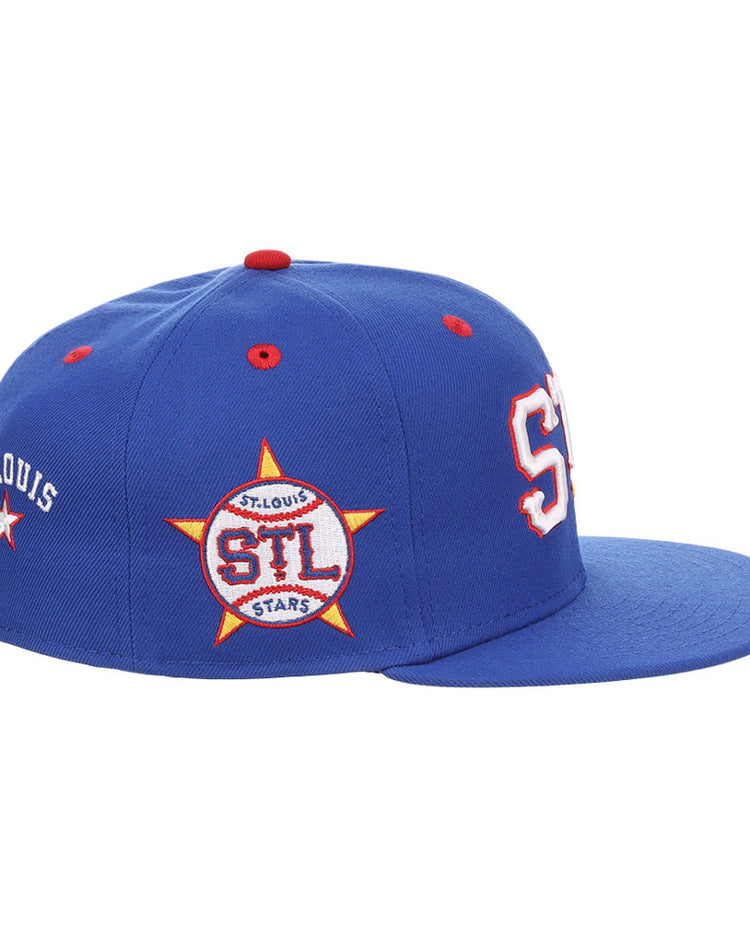 The Ebbets Field St. Louis Stars NLB Varsity Fitted Ballcap is a blue cap with red and white accents, large white and red STL letters on the front, ST. LOUIS text, and an STL-in-yellow-star patch on the side.