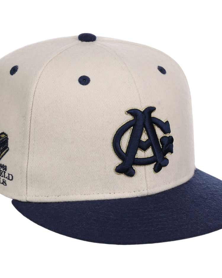 The Ebbets Field Chicago American Giants NLB Ballpark Fitted Ballcap features a beige crown, navy blue brim and button, navy embroidered front logo, and a commemorative side patch.