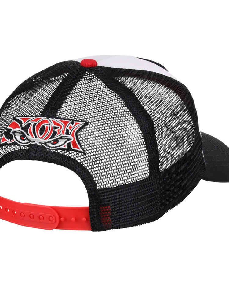 The Lake Elsinore Storm MiLB Trucker Ballcap by Ebbets Field is a black mesh hat with a red adjustable strap and a colorful embroidered patch of stylized eyes and bold lettering on the back. The front and bill are partially visible.
