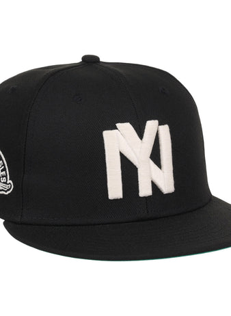The Ebbets Field Brooklyn Eagles NLB Fitted Ballcap is a black cap with large white overlapping NY letters on the front and a patch showing an eagle and 