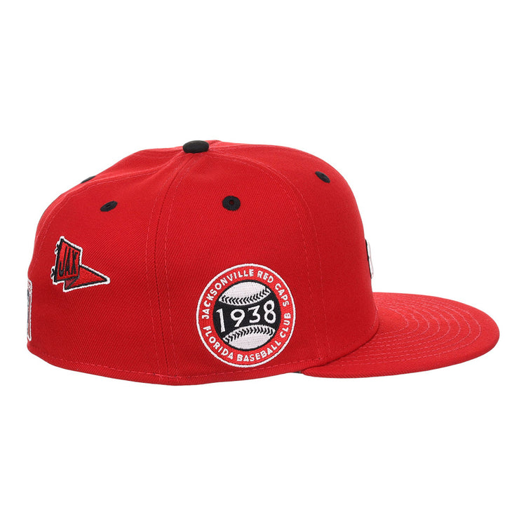 The Ebbets Field Jacksonville Red Caps NLB Varsity Fitted Ballcap is red with a flat brim, black ventilation holes, a side patch reading 