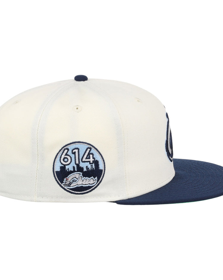 The Ebbets Field Columbus Clippers MiLB Snapback Ballcap is cream-colored with a navy bill and a circular side patch showing 