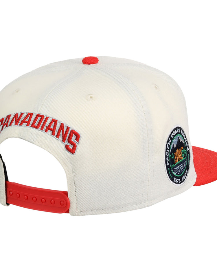 The Ebbets Field Vancouver Canadians MiLB Snapback Ballcap features a white crown, red brim, red adjustable snapback, CANADIANS embroidered in red on the back, and a circular patch on the side.