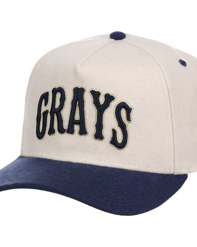 The Ebbets Field Homestead Grays NLB Ballpark A-Frame Ballcap is cream-colored with a navy brim and button, and features 