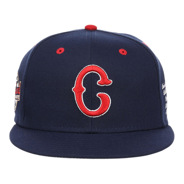 The Ebbets Field Cleveland Buckeyes NLB Varsity Fitted Ballcap features a navy base, red eyelets, a slightly curved brim, and an embroidered red and white 