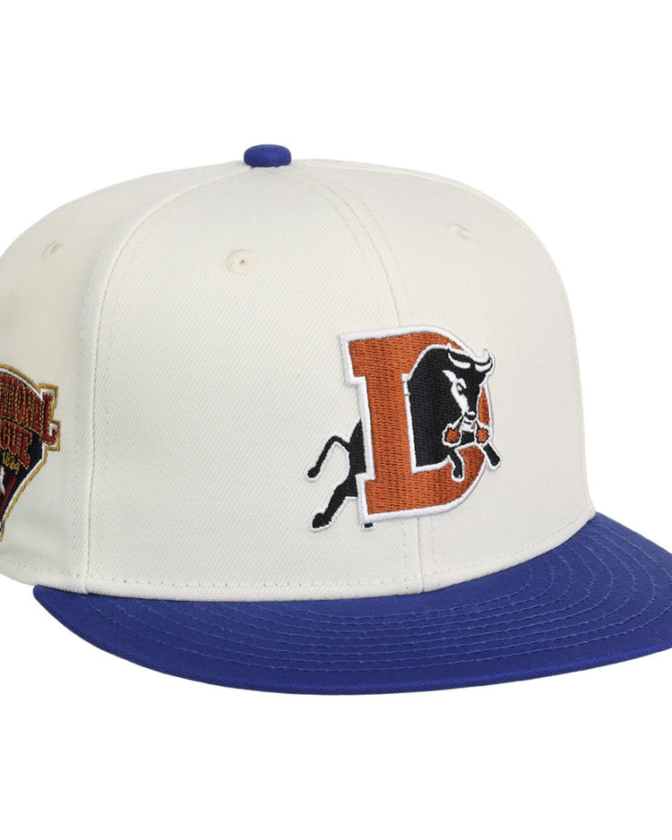 The Ebbets Field Durham Bulls MiLB Two Tone Snapback Ballcap features a white crown, blue brim, bold orange and black 