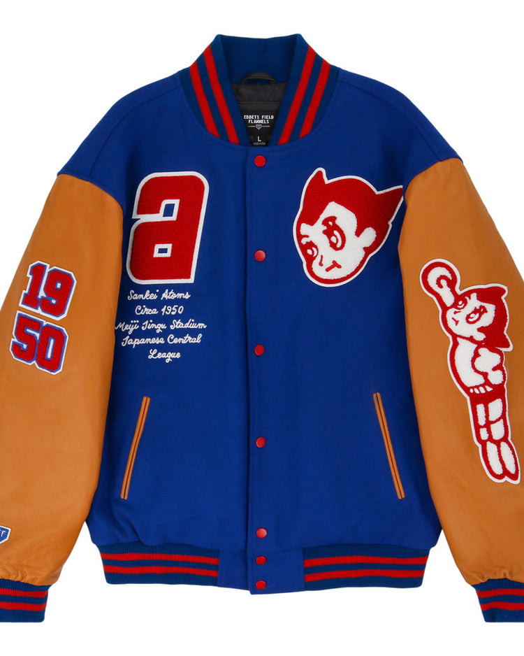 The Sankei Atoms Dna Varsity Jacket by Ebbets Field is a blue varsity jacket with tan leather sleeves, red and white patches featuring 