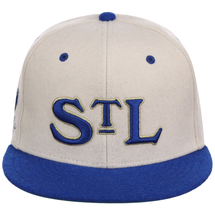 The Ebbets Field St. Louis Stars NLB Ballpark Fitted Ballcap has a beige crown, blue bill, blue accents, and features “STL” in blue and gold on the front.
