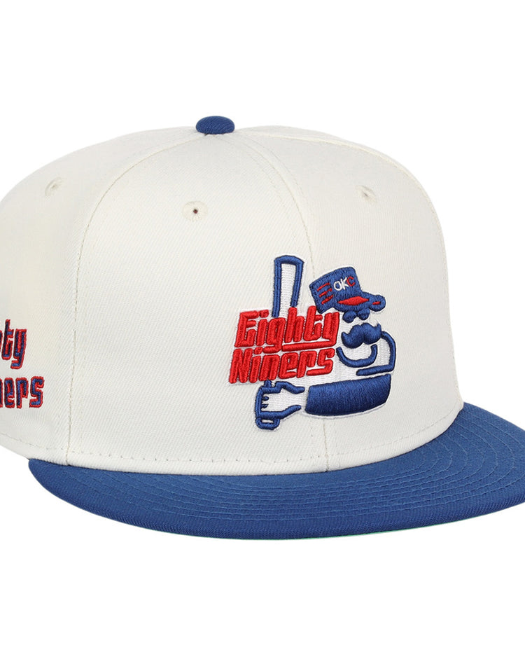 The Ebbets Field Oklahoma City 89Ers MiLB Logo Wordmark Snapback Ballcap features a white crown, blue brim, an embroidered cartoon mascot with 