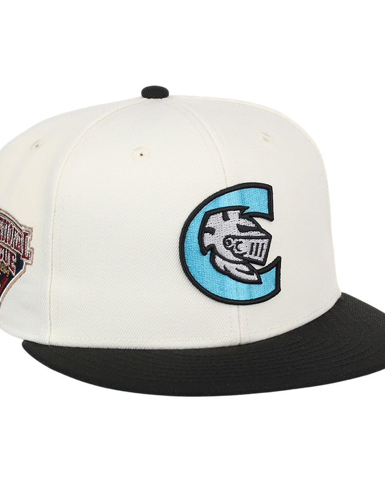 The Ebbets Field Charlotte Knights MiLB Snapback Ballcap is a white cap with a black brim, a large blue and black C logo with a fish and Roman numerals on the front, plus a brown Continental League patch on the side.