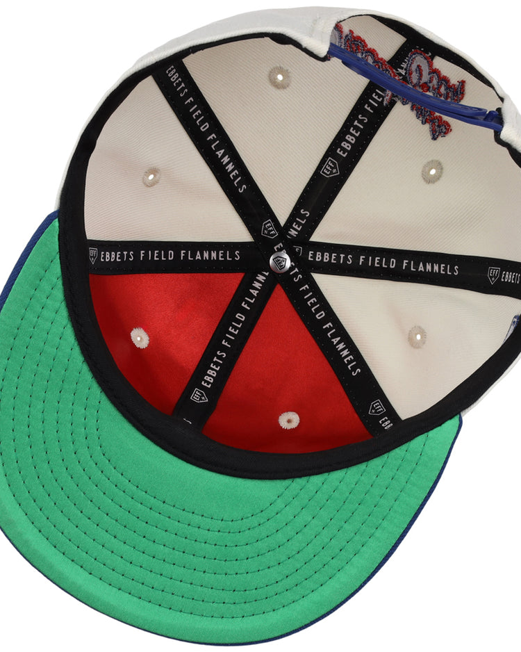 Inside view of the Oklahoma City Dodgers MiLB Snapback Ballcap by Ebbets Field, showing black branded lining, red and white interior panels, white stitched eyelets, and a green underbrim.
