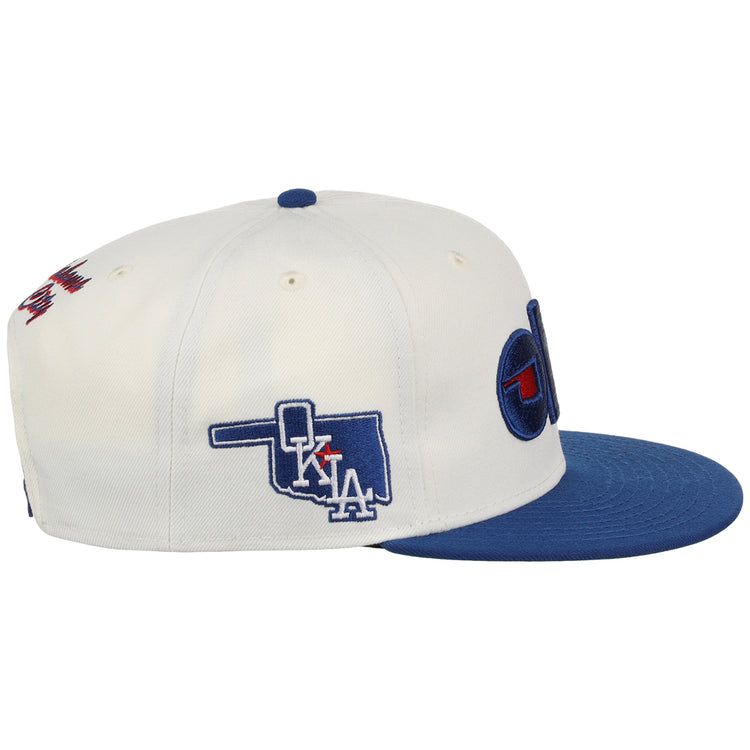 The Ebbets Field Oklahoma City Dodgers MiLB Snapback Ballcap is a white cap with a blue brim, side embroidery of Oklahoma with 
