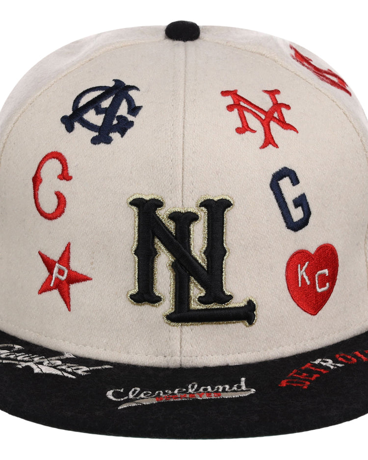 The Ebbets Field Negro League Baseball NLB Ballpark Fitted Ballcap is a beige and black cap featuring embroidered NL on the front and colorful Negro League team logos and icons scattered around.