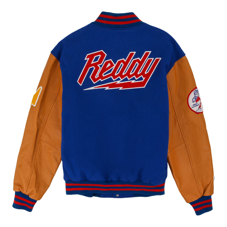 The Reddy Kilowatt DNA Varsity Jacket by Ebbets Field features a blue wool body, tan leather sleeves, red and blue striped cuffs, 