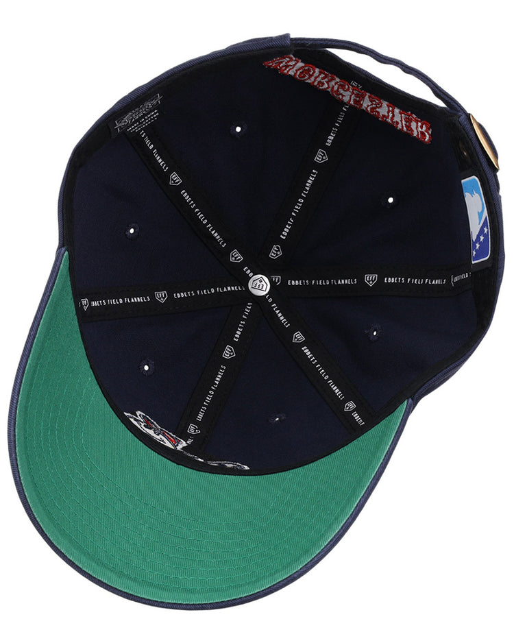 The underside of the Worcester Red Sox MiLB Dad Ballcap by Ebbets Field features a green brim, multiple logos, stitched black taping with white text, a gold buckle strap, and a blue patch on the inner back.