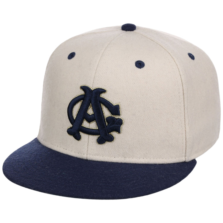 The Ebbets Field Chicago American Giants NLB Ballpark Fitted Ballcap features a cream color with a navy brim and embroidered navy and gold interlocking AC logo, plus ventilation holes on top.