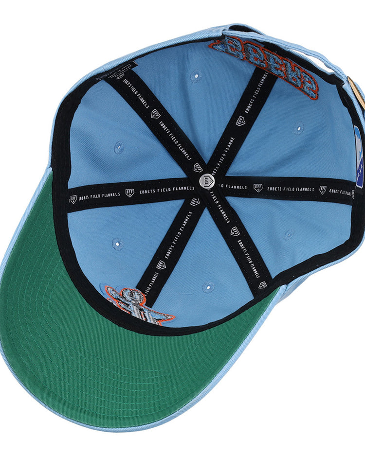 The inside view of the Ebbets Field Inland Empire 66Ers MiLB Dad Ballcap features a light blue exterior, green underside brim, black interior taping with white text, and embroidered patches on the inner crown.