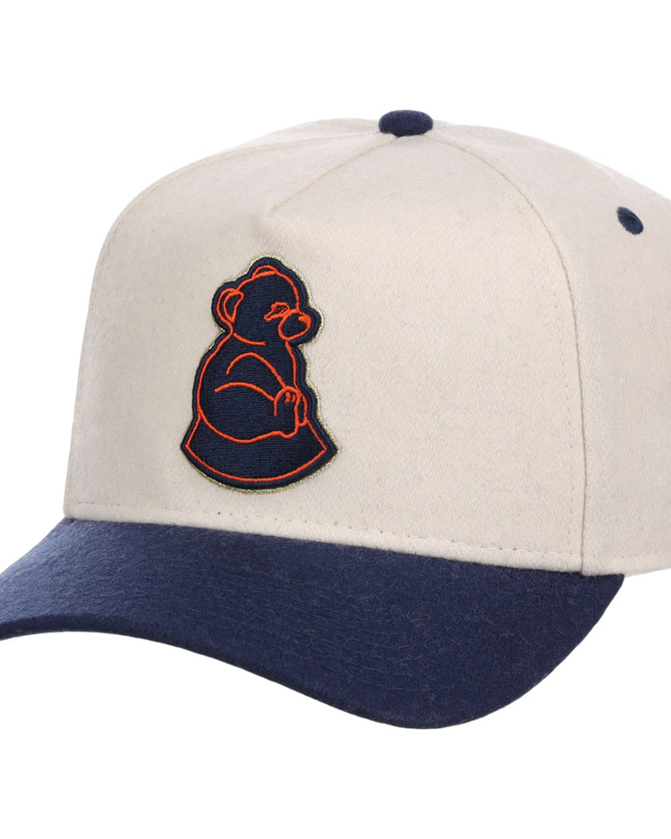 The Ebbets Field San Francisco Sea Lions NLB Ballpark A-Frame Ballcap features a beige crown, navy blue brim and button, plus an embroidered orange and navy outline of a seated bear on the front.