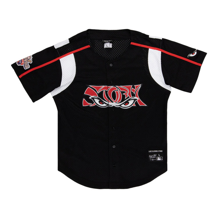 The Ebbets Field Lake Elsinore Storm MiLB Button Down Jersey is a black short-sleeve baseball jersey with white and red accents, mesh panels, a stylized eyes logo on the chest, and patches on the left sleeve and lower right front.