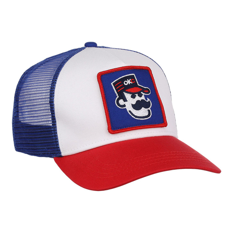 The Ebbets Field Oklahoma City 89Ers MiLB Trucker Ballcap features a white front panel, blue mesh back, red brim, and a patch of a cartoon face with sunglasses, mustache, red hat, and OKC letters.