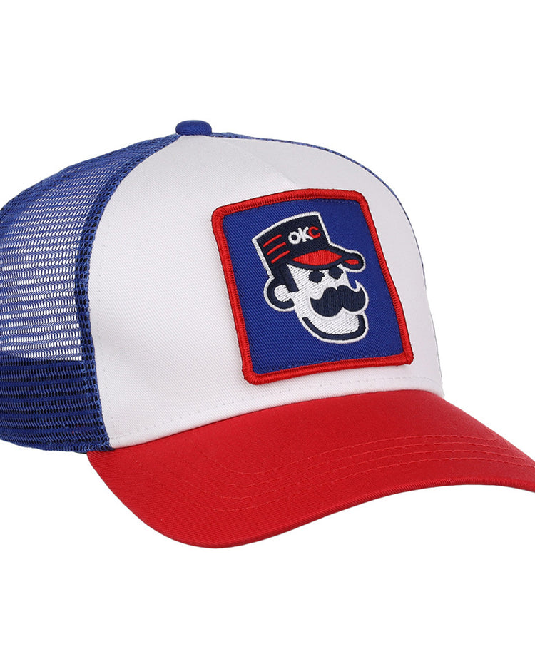 The Ebbets Field Oklahoma City 89Ers MiLB Trucker Ballcap features a white front panel, blue mesh back, red brim, and a patch of a cartoon face with sunglasses, mustache, red hat, and OKC letters.