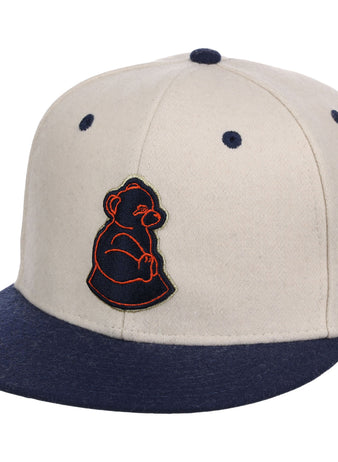 The Ebbets Field San Francisco Sea Lions NLB Ballpark Fitted Ballcap is beige with a navy brim and button, featuring a navy bear cub logo outlined in orange on the front.