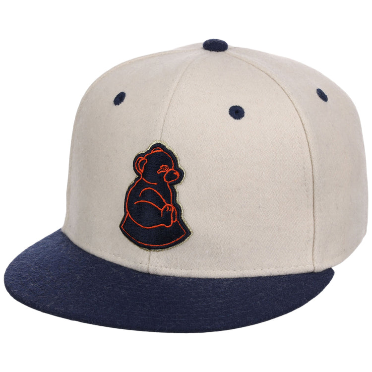 The Ebbets Field San Francisco Sea Lions NLB Ballpark Fitted Ballcap is beige with a navy brim and button, featuring a navy bear cub logo outlined in orange on the front.