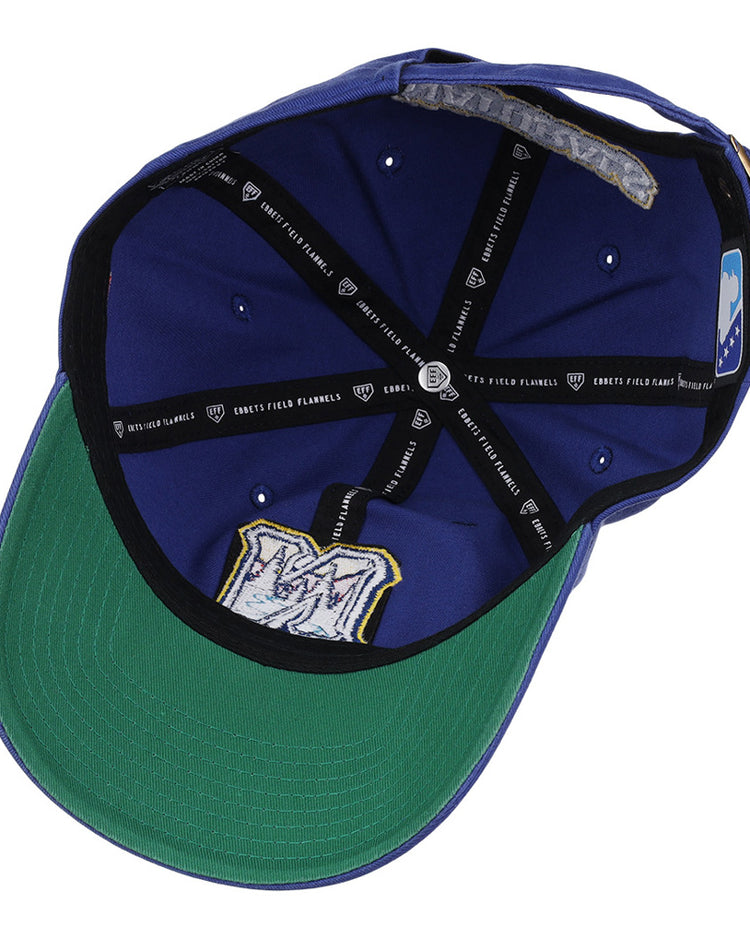 An inside view of the Northwest Arkansas Naturals MiLB Dad Ballcap by Ebbets Field, featuring a blue crown, green brim, black inner bands with the Ebbets Field label, and a stitched M logo on the underside.