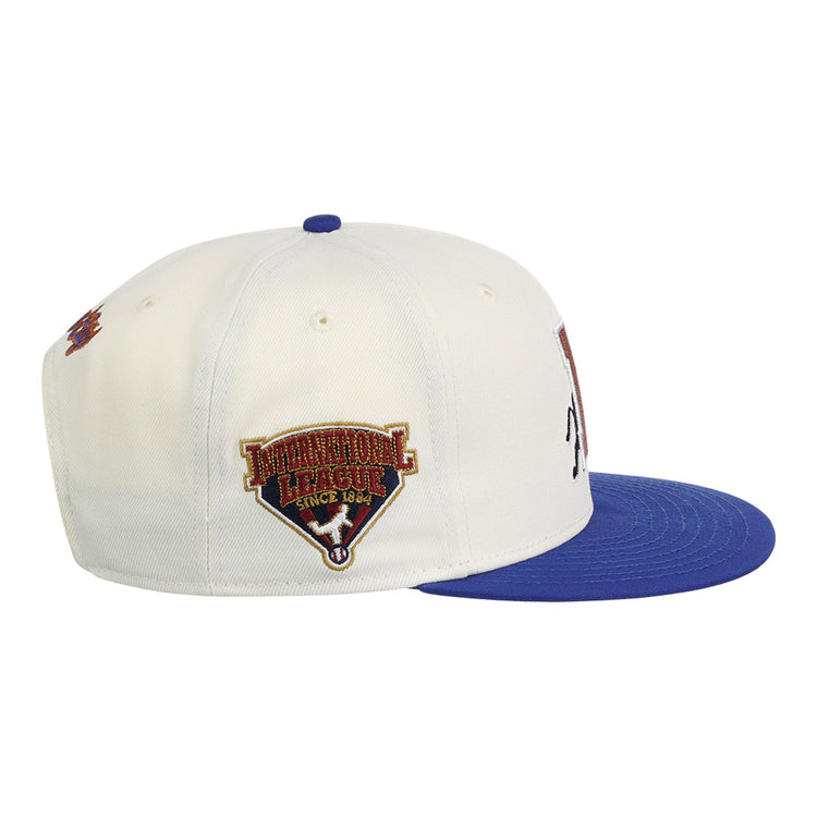 The Ebbets Field Durham Bulls MiLB Two Tone Snapback Ballcap is a white cap with a blue brim, featuring an embroidered Pinnacle League Since 1844 patch on the side.