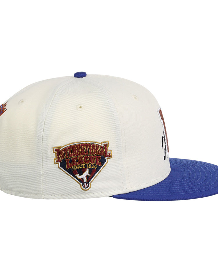 The Ebbets Field Durham Bulls MiLB Two Tone Snapback Ballcap is a white cap with a blue brim, featuring an embroidered Pinnacle League Since 1844 patch on the side.